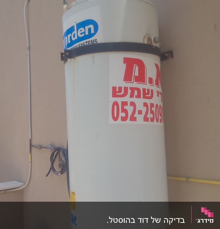 דוד שמש מותקן על קיר עם צינורות וחיבורים